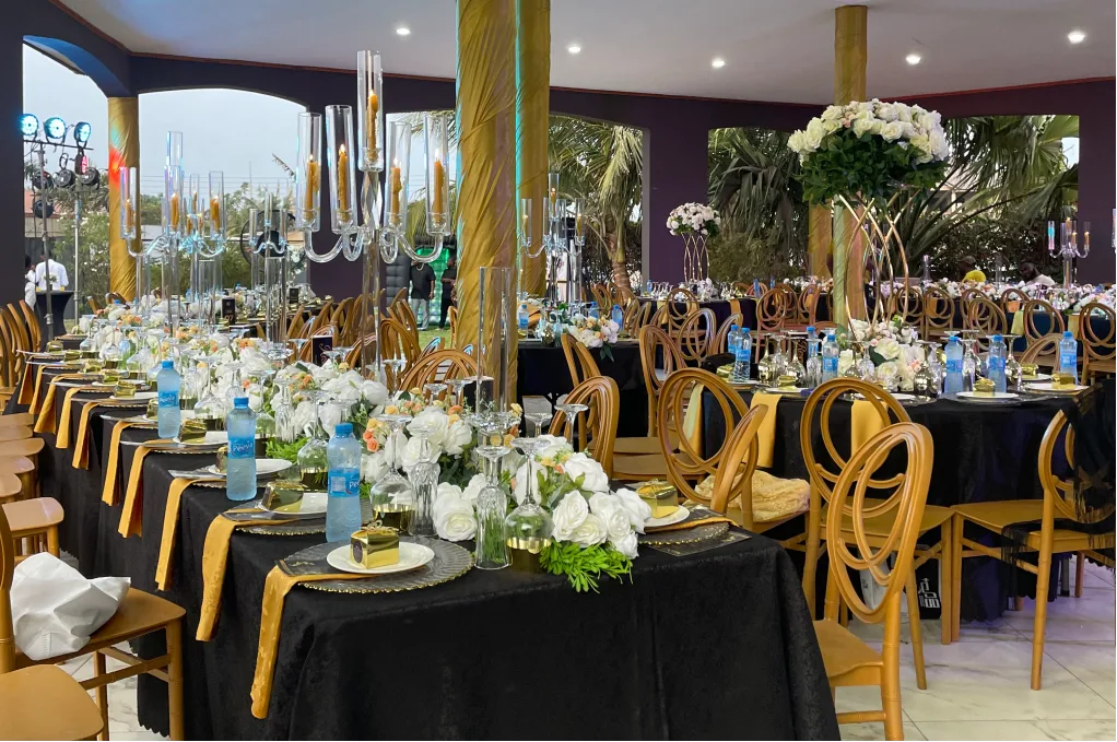 Golden chairs and black tablecloths with white floral arrangements